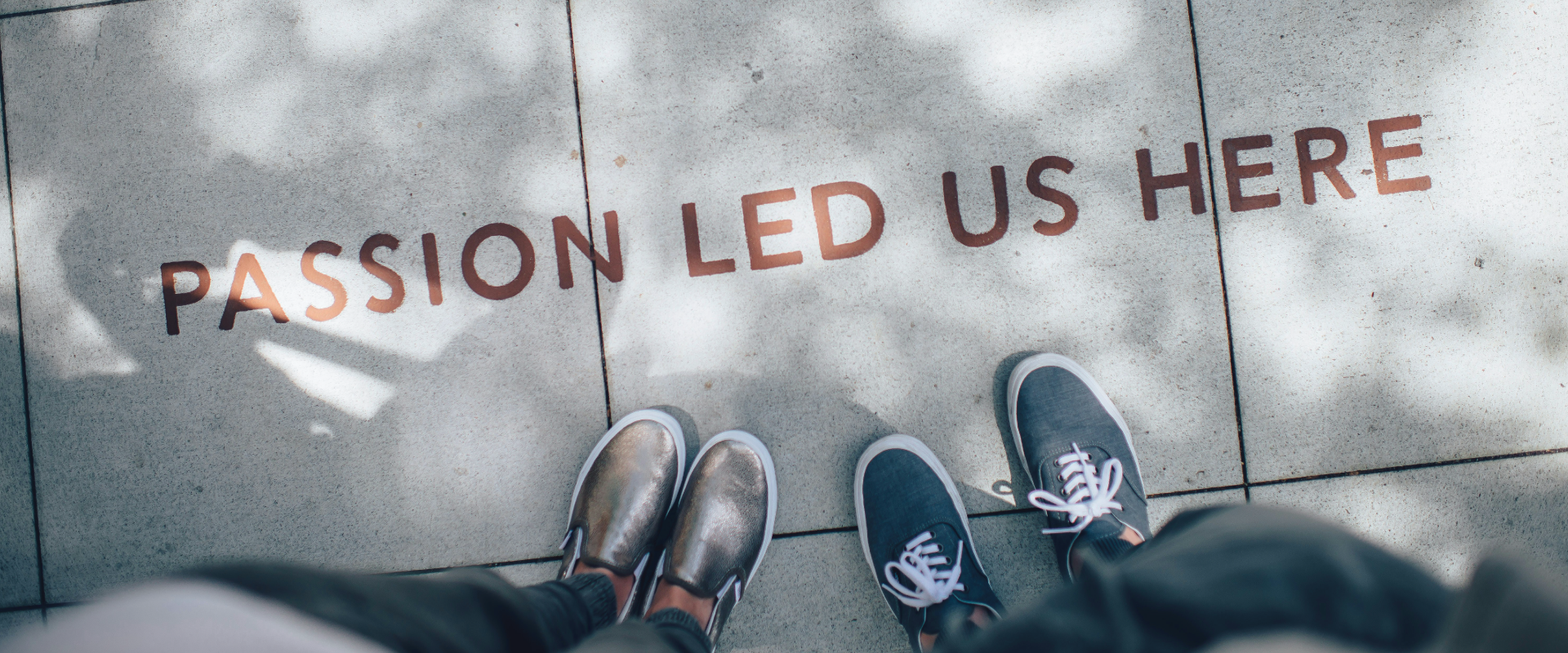 he words 'Passion led us here' written on the floor with two people walking toward it